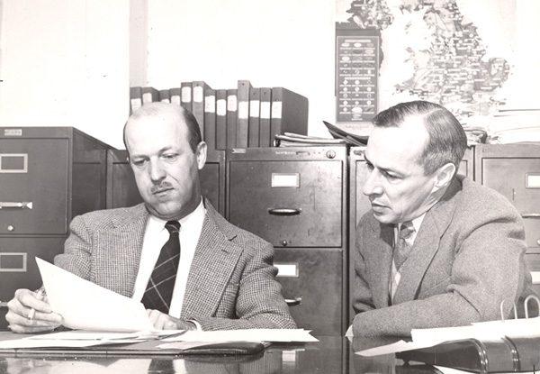 2 men reviewing materials in an office